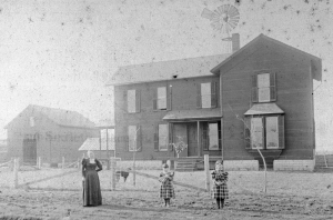The author's grandmother, Mabel Lantz Holzhueter (right), her sister Edie, and her mother, Amelia Minnich Lantz in front of the home place farm on modern Ill. Route 59, Wheatland Township, Will County, Illinois.