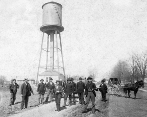 Oswego's first fire brigade poses in front of the village's new water tower in the summer of 1895. The tank atop the tower was made of basswood. (Little White School Museum collection)