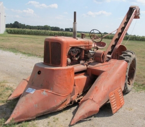 An Allis-Chalmers WD tractor wearing its attached two-row corn picker.