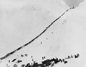 This iconic photo of Klondike gold-seekers packing their one ton of supplies over the Chilkoot Trail in 1898 illustrates some of the realities of the gold rush. (Library and Archives of Canada photo)
